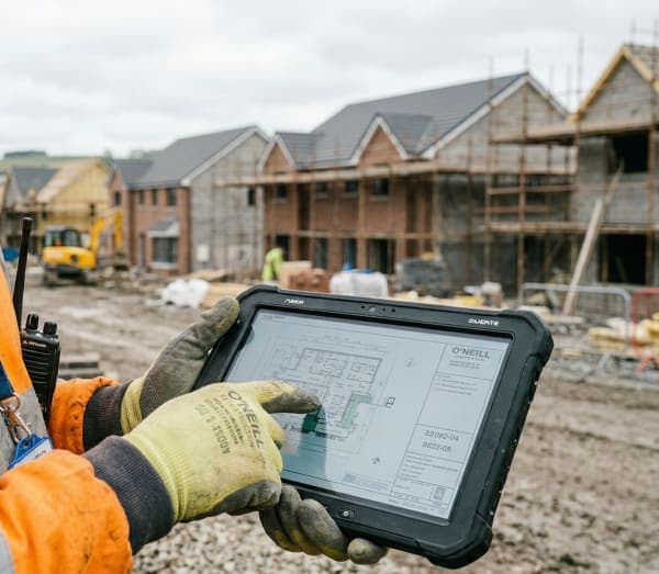 Builder on a construction site with a tablet